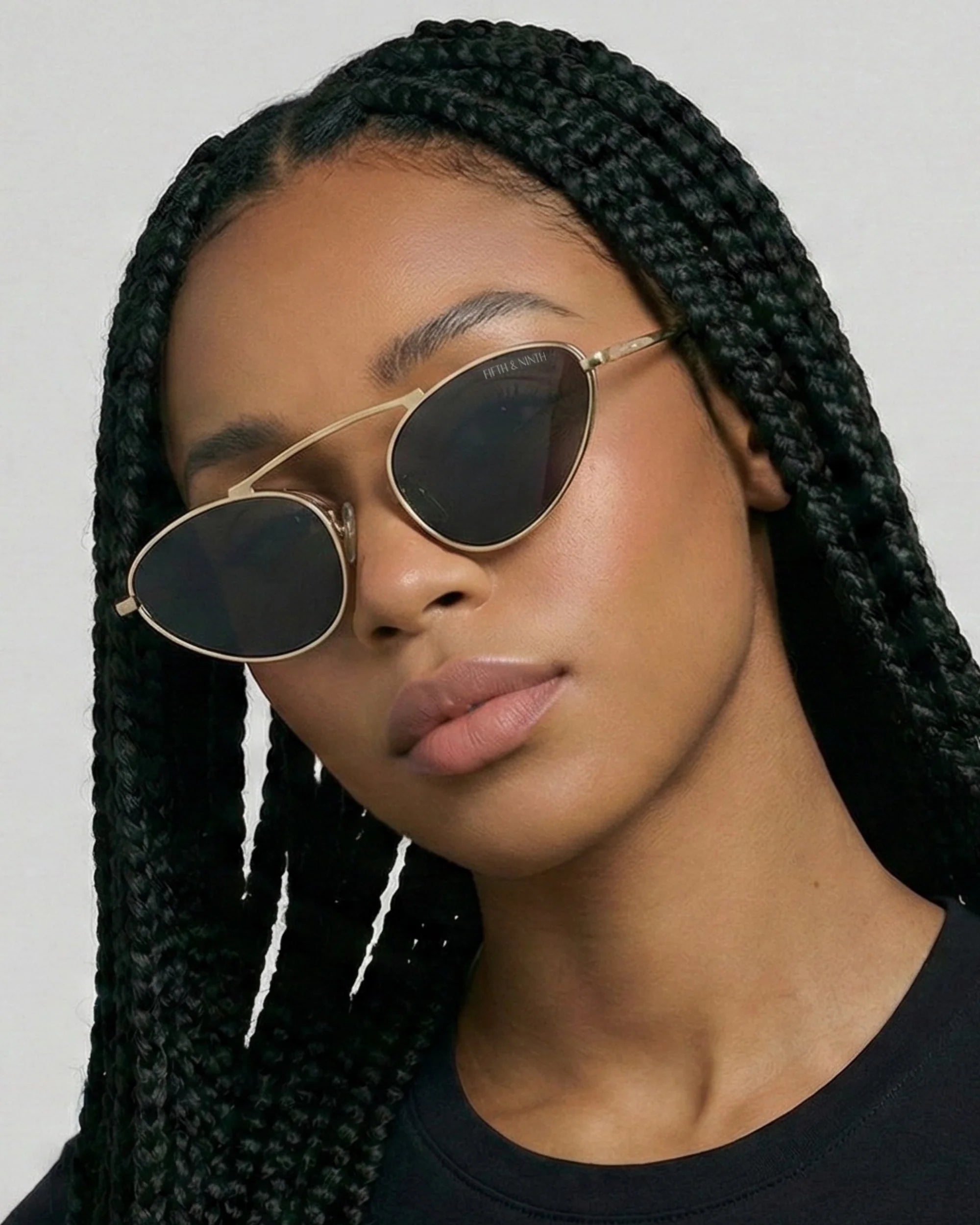 Modern gold metal cat-eye sunglasses with black polarized lenses and a sleek raised bridge silhouette.