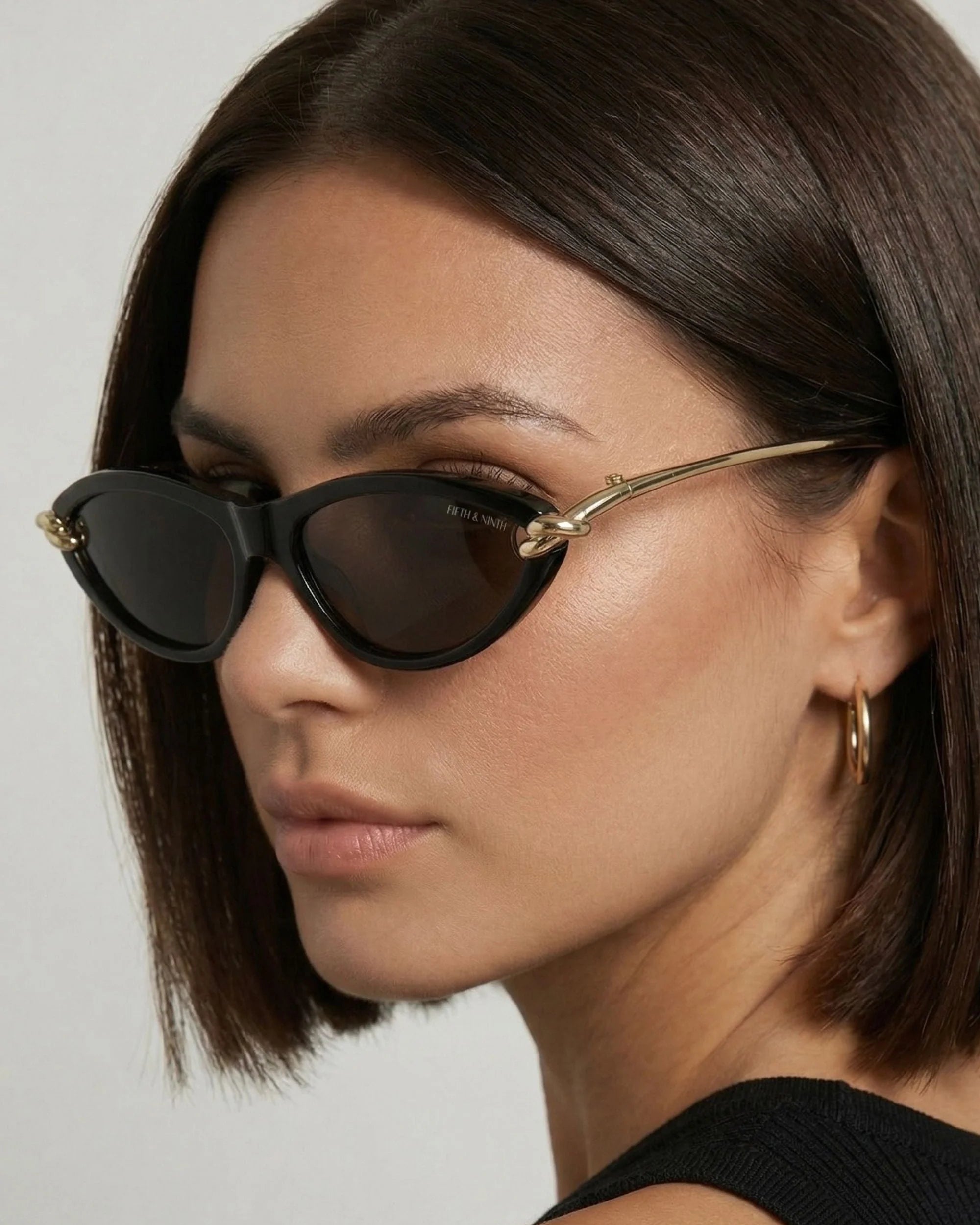 Elegant black cat-eye sunglasses featuring polarized lenses and sculptural gold side detailing