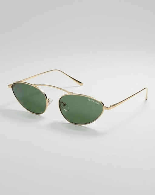 Gold-framed sunglasses with green lenses on a light gray background
