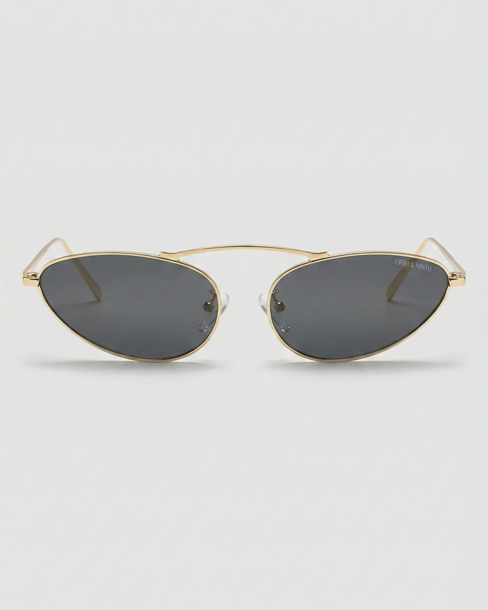 Daphne polarized cat-eye sunglasses with a lightweight gold metal frame, black lenses, and a raised bridge design.