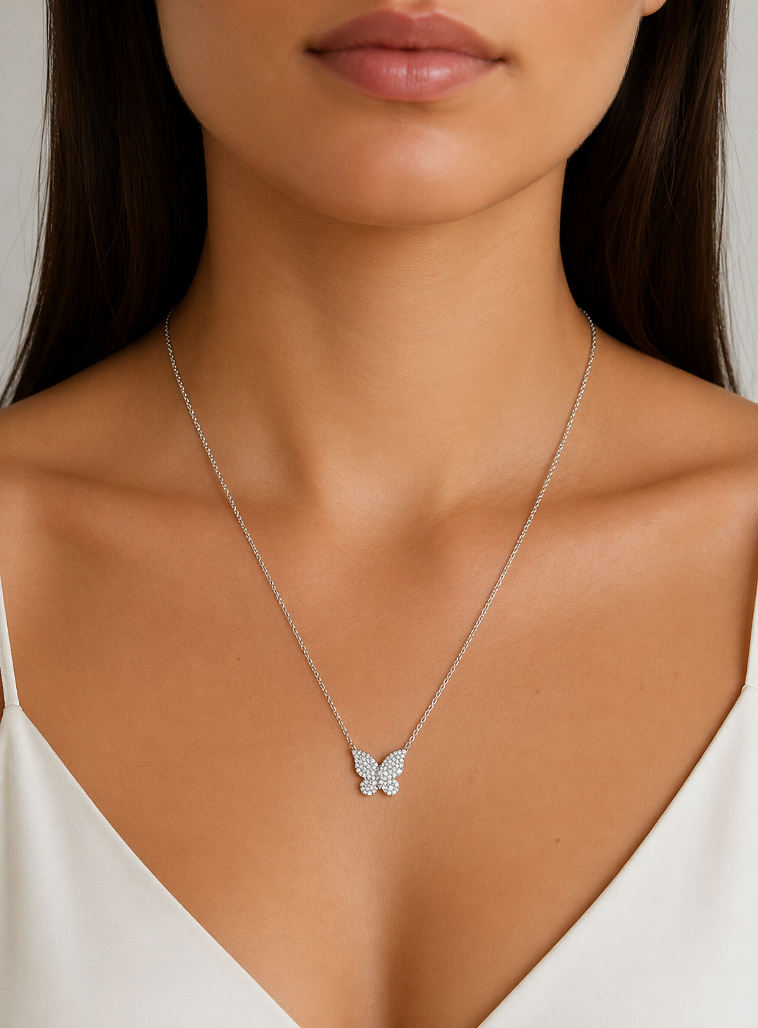 Model wearing a silver butterfly necklace with sparkling cubic zirconia pendant, elegant dainty jewelry on neutral background